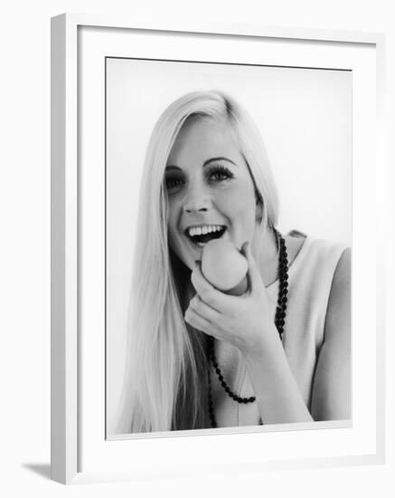 A Woman Poses Holding an Apple Up to Her Mouth-null-Framed Photographic Print
