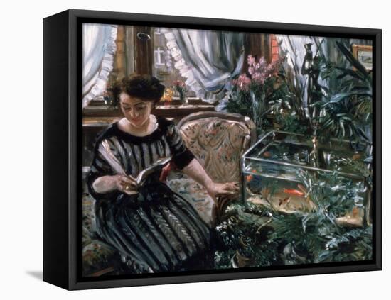 A Woman Reading Near a Goldfish Tank-Lovis Corinth-Framed Premier Image Canvas