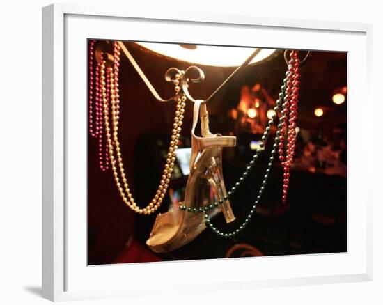 A Woman's High Heeled Shoe Hangs with Some Mardi Gras Beads-null-Framed Photographic Print