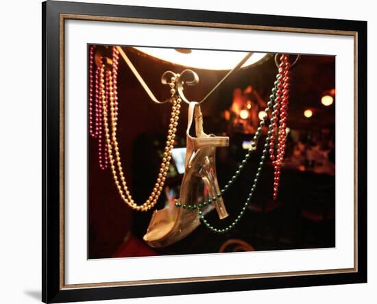 A Woman's High Heeled Shoe Hangs with Some Mardi Gras Beads-null-Framed Photographic Print