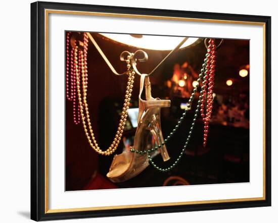 A Woman's High Heeled Shoe Hangs with Some Mardi Gras Beads-null-Framed Photographic Print