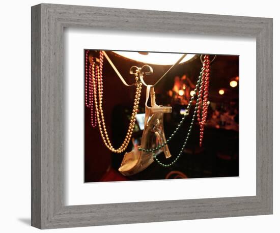 A Woman's High Heeled Shoe Hangs with Some Mardi Gras Beads-null-Framed Photographic Print