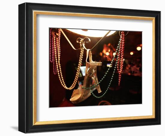 A Woman's High Heeled Shoe Hangs with Some Mardi Gras Beads-null-Framed Photographic Print