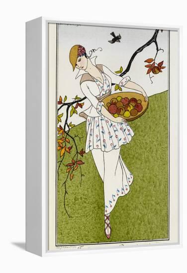 A woman wearing a silk printed outfit, and straw hat She is carrying a bowl of fruit-Georges Barbier-Framed Premier Image Canvas