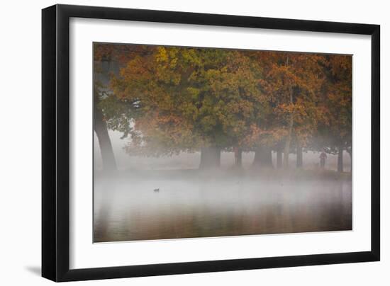 A Woman with Her Dog Stands by a Mist Shrouded Pond in Richmond Park in Autumn-Alex Saberi-Framed Photographic Print