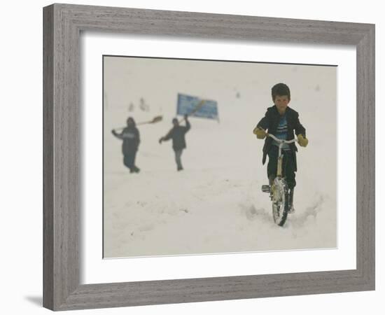 A Young Afghan Boy Rides His Bicycle on a Snow Covered Street-null-Framed Photographic Print