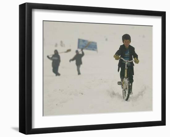 A Young Afghan Boy Rides His Bicycle on a Snow Covered Street-null-Framed Photographic Print