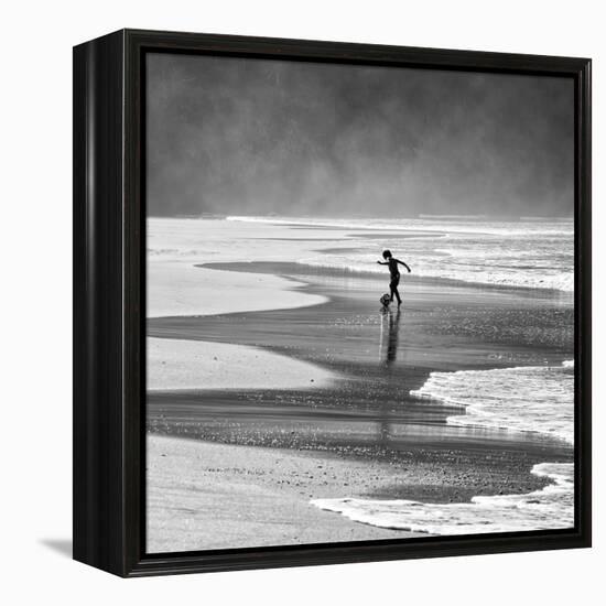 A Young Boy Kicks a Ball on Itamambuca Beach in Ubatuba, Brazil-Alex Saberi-Framed Premier Image Canvas