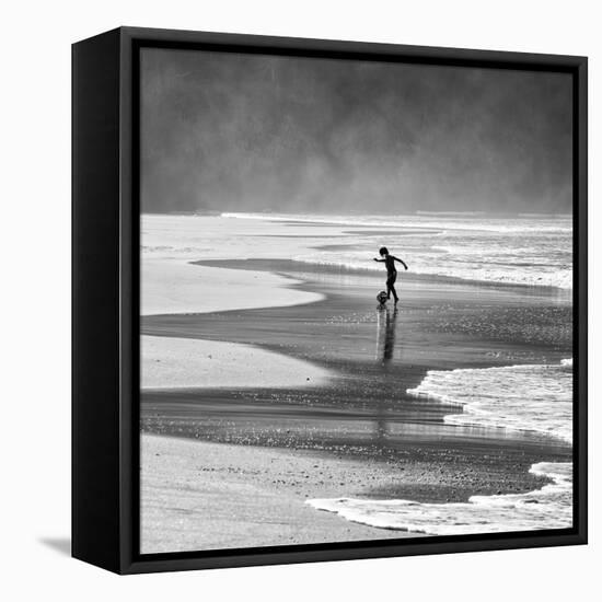 A Young Boy Kicks a Ball on Itamambuca Beach in Ubatuba, Brazil-Alex Saberi-Framed Premier Image Canvas