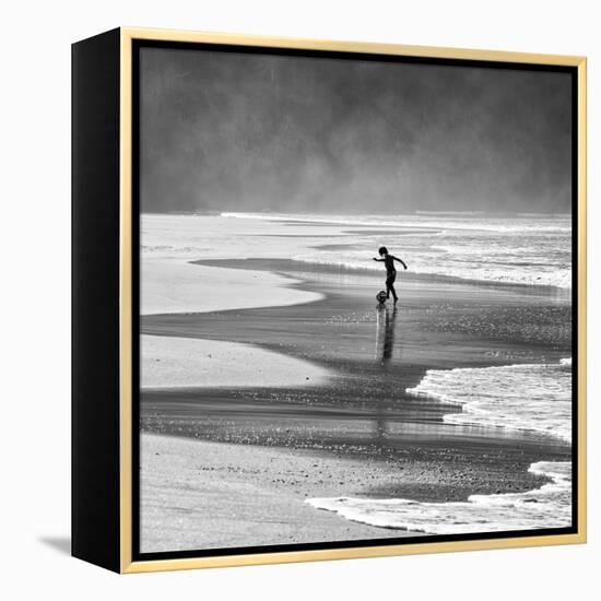 A Young Boy Kicks a Ball on Itamambuca Beach in Ubatuba, Brazil-Alex Saberi-Framed Premier Image Canvas