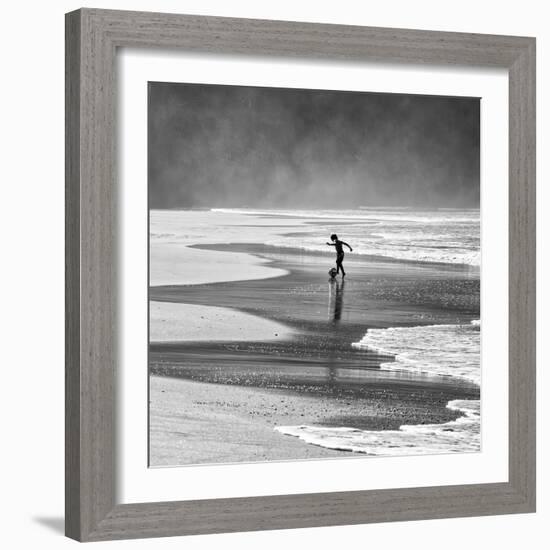 A Young Boy Kicks a Ball on Itamambuca Beach in Ubatuba, Brazil-Alex Saberi-Framed Photographic Print