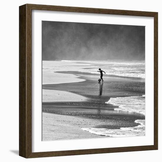 A Young Boy Kicks a Ball on Itamambuca Beach in Ubatuba, Brazil-Alex Saberi-Framed Photographic Print