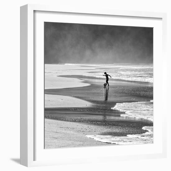 A Young Boy Kicks a Ball on Itamambuca Beach in Ubatuba, Brazil-Alex Saberi-Framed Photographic Print