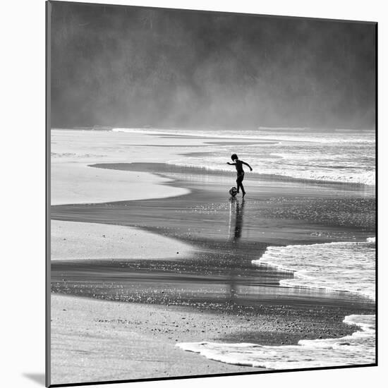 A Young Boy Kicks a Ball on Itamambuca Beach in Ubatuba, Brazil-Alex Saberi-Mounted Photographic Print