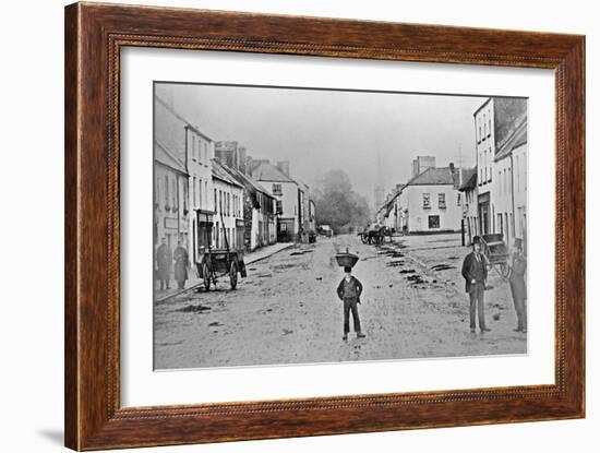 A Young Delivery Boy Stands Nonchalantly in the Main Street of Clonmorris-Thomas Wynne-Framed Giclee Print