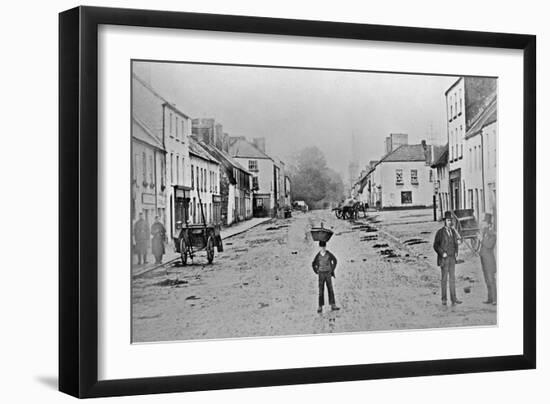 A Young Delivery Boy Stands Nonchalantly in the Main Street of Clonmorris-Thomas Wynne-Framed Giclee Print