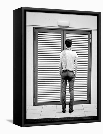A Young Man Standing in the Street Looking at a Pair of Doors-India Hobson-Framed Premier Image Canvas