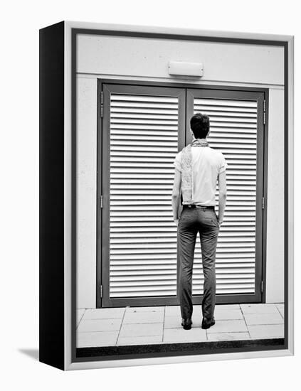 A Young Man Standing in the Street Looking at a Pair of Doors-India Hobson-Framed Premier Image Canvas