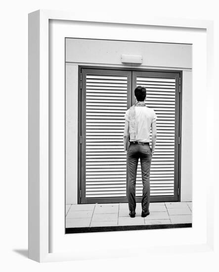 A Young Man Standing in the Street Looking at a Pair of Doors-India Hobson-Framed Photographic Print