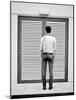 A Young Man Standing in the Street Looking at a Pair of Doors-India Hobson-Mounted Photographic Print