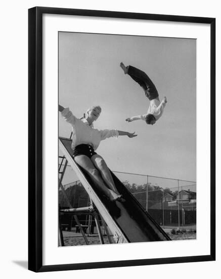 Acrobat and Actor Russ Tamblyn Doing a Flip at a Playground with Movie Actress Venetia Stevenson-Allan Grant-Framed Premium Photographic Print