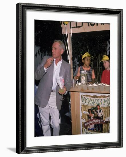 Actor Paul Newman Standing Next to a Stand Sell Newman's Own Virgin Lemonade-null-Framed Premium Photographic Print