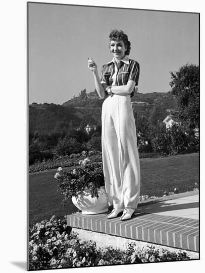 Actress Claudette Colbert Holding Cigarette as She Suns Herself on Terrace of Her Holmby Hills Home-Alfred Eisenstaedt-Mounted Premium Photographic Print