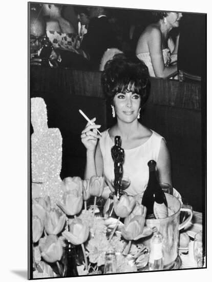 Actress Elizabeth Taylor at Hollywood Party After Winning Oscar, Which is on Table in Front of Her-Allan Grant-Mounted Premium Photographic Print