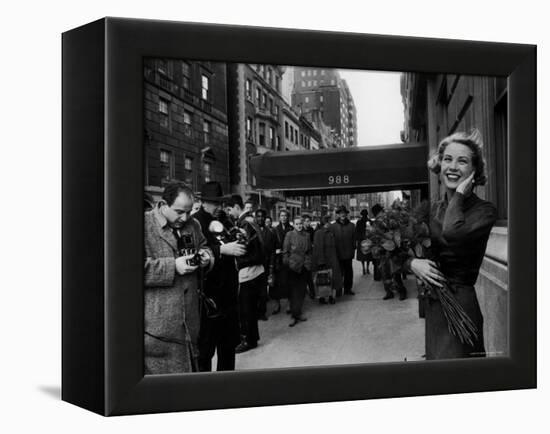 Actress Grace Kelly in Casual Pose with Armful of Roses Standing on Sidewalk During Shopping Trip-Lisa Larsen-Framed Premier Image Canvas
