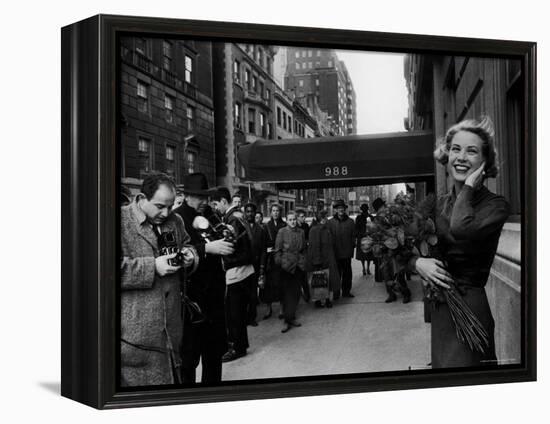 Actress Grace Kelly in Casual Pose with Armful of Roses Standing on Sidewalk During Shopping Trip-Lisa Larsen-Framed Premier Image Canvas