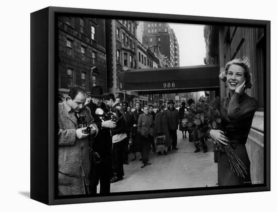 Actress Grace Kelly in Casual Pose with Armful of Roses Standing on Sidewalk During Shopping Trip-Lisa Larsen-Framed Premier Image Canvas