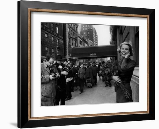 Actress Grace Kelly in Casual Pose with Armful of Roses Standing on Sidewalk During Shopping Trip-Lisa Larsen-Framed Premium Photographic Print
