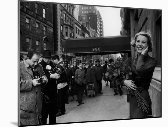 Actress Grace Kelly in Casual Pose with Armful of Roses Standing on Sidewalk During Shopping Trip-Lisa Larsen-Mounted Premium Photographic Print