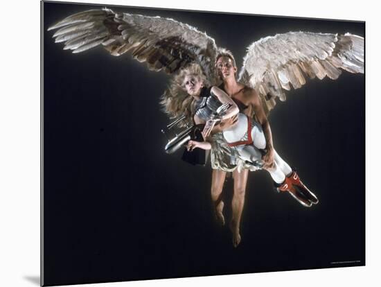 Actress Jane Fonda Being Carried by Guardian Angel in a Scene from Roger Vadim's Film "Barbarella"-Carlo Bavagnoli-Mounted Premium Photographic Print