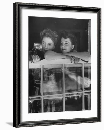 Actress Joan Fontaine with Actress Sister Olivia de Havilland Looking Out of Open Window at Home-Bob Landry-Framed Premium Photographic Print