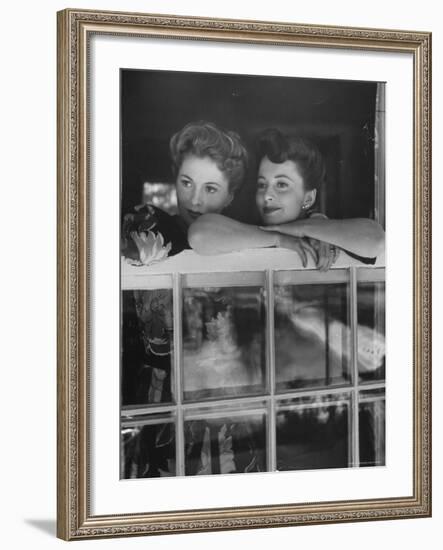 Actress Joan Fontaine with Actress Sister Olivia de Havilland Looking Out of Open Window at Home-Bob Landry-Framed Premium Photographic Print