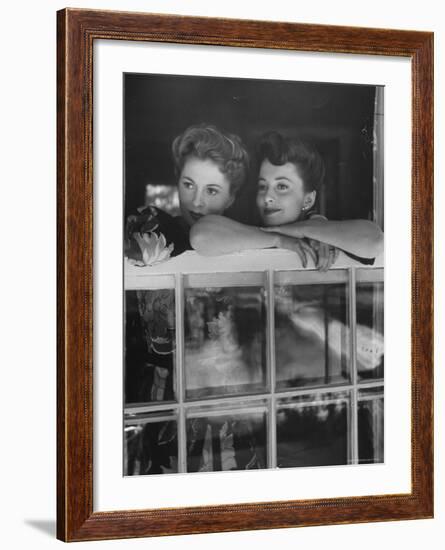 Actress Joan Fontaine with Actress Sister Olivia de Havilland Looking Out of Open Window at Home-Bob Landry-Framed Premium Photographic Print