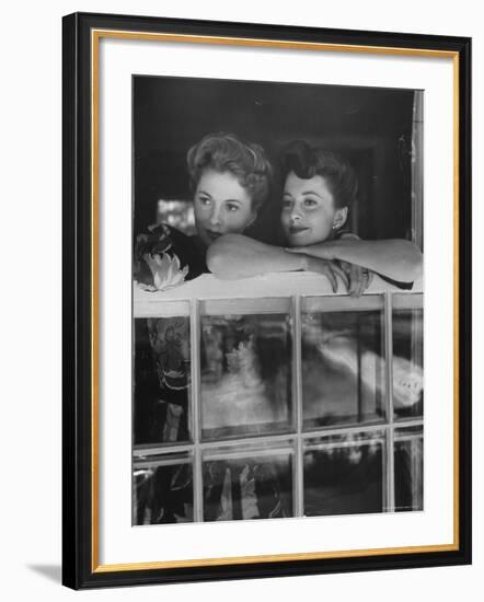 Actress Joan Fontaine with Actress Sister Olivia de Havilland Looking Out of Open Window at Home-Bob Landry-Framed Premium Photographic Print