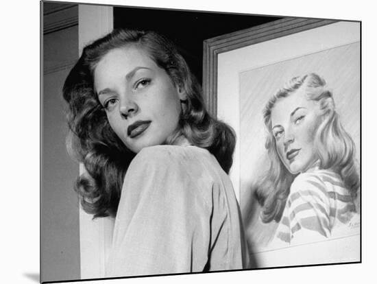 Actress Lauren Bacall Posing in Front of Portrait Drawing of Herself in Suite at the Gotham Hotel-Nina Leen-Mounted Premium Photographic Print