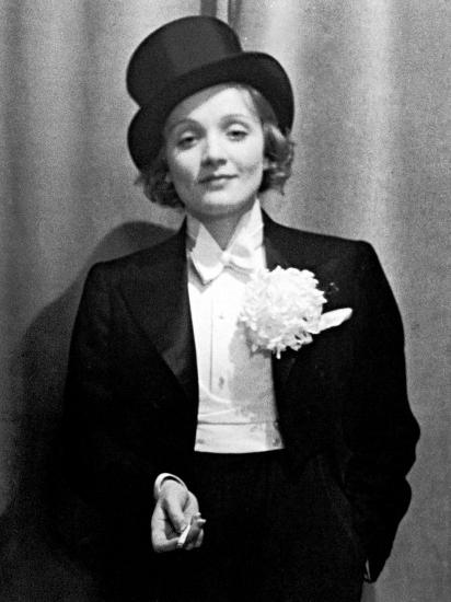 'Actress Marlene Dietrich Wearing Tuxedo, Top Hat, and Holding