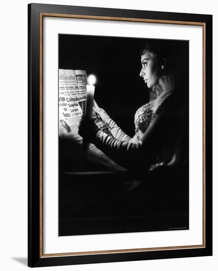 Actress Sophia Loren Reading Newspaper by Candlelight While in Costume for "Madame Sans Gene"-Alfred Eisenstaedt-Framed Premium Photographic Print