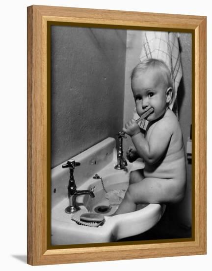 Adorable Baby Brushing Teeth While Sitting in Sink-null-Framed Premier Image Canvas