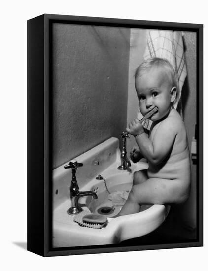 Adorable Baby Brushing Teeth While Sitting in Sink-null-Framed Premier Image Canvas