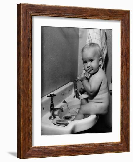 Adorable Baby Brushing Teeth While Sitting in Sink--Framed Photographic Print