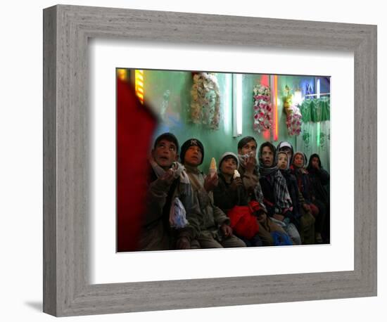 Afghan Boys Watch a Movie on a Television, Unseen, as They Eat Ice Cream at an Ice Cream Shop-Rodrigo Abd-Framed Photographic Print