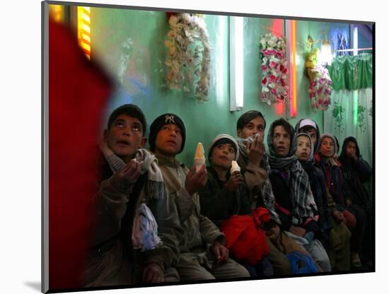 Afghan Boys Watch a Movie on a Television, Unseen, as They Eat Ice Cream at an Ice Cream Shop-Rodrigo Abd-Mounted Photographic Print
