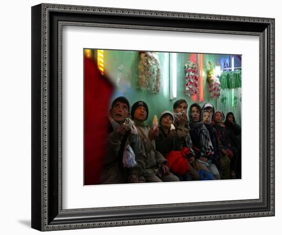 Afghan Boys Watch a Movie on a Television, Unseen, as They Eat Ice Cream at an Ice Cream Shop-Rodrigo Abd-Framed Photographic Print