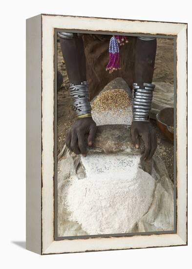 Africa, Ethiopia, Southern Omo, Karo Tribe. Woman grinding grain into flour with stone.-Ellen Goff-Framed Premier Image Canvas