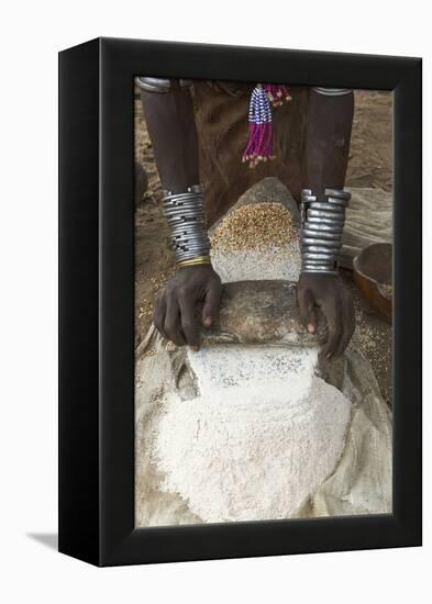 Africa, Ethiopia, Southern Omo, Karo Tribe. Woman grinding grain into flour with stone.-Ellen Goff-Framed Premier Image Canvas