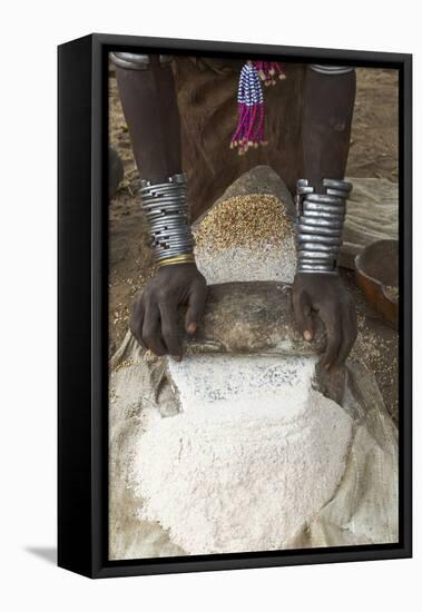 Africa, Ethiopia, Southern Omo, Karo Tribe. Woman grinding grain into flour with stone.-Ellen Goff-Framed Premier Image Canvas